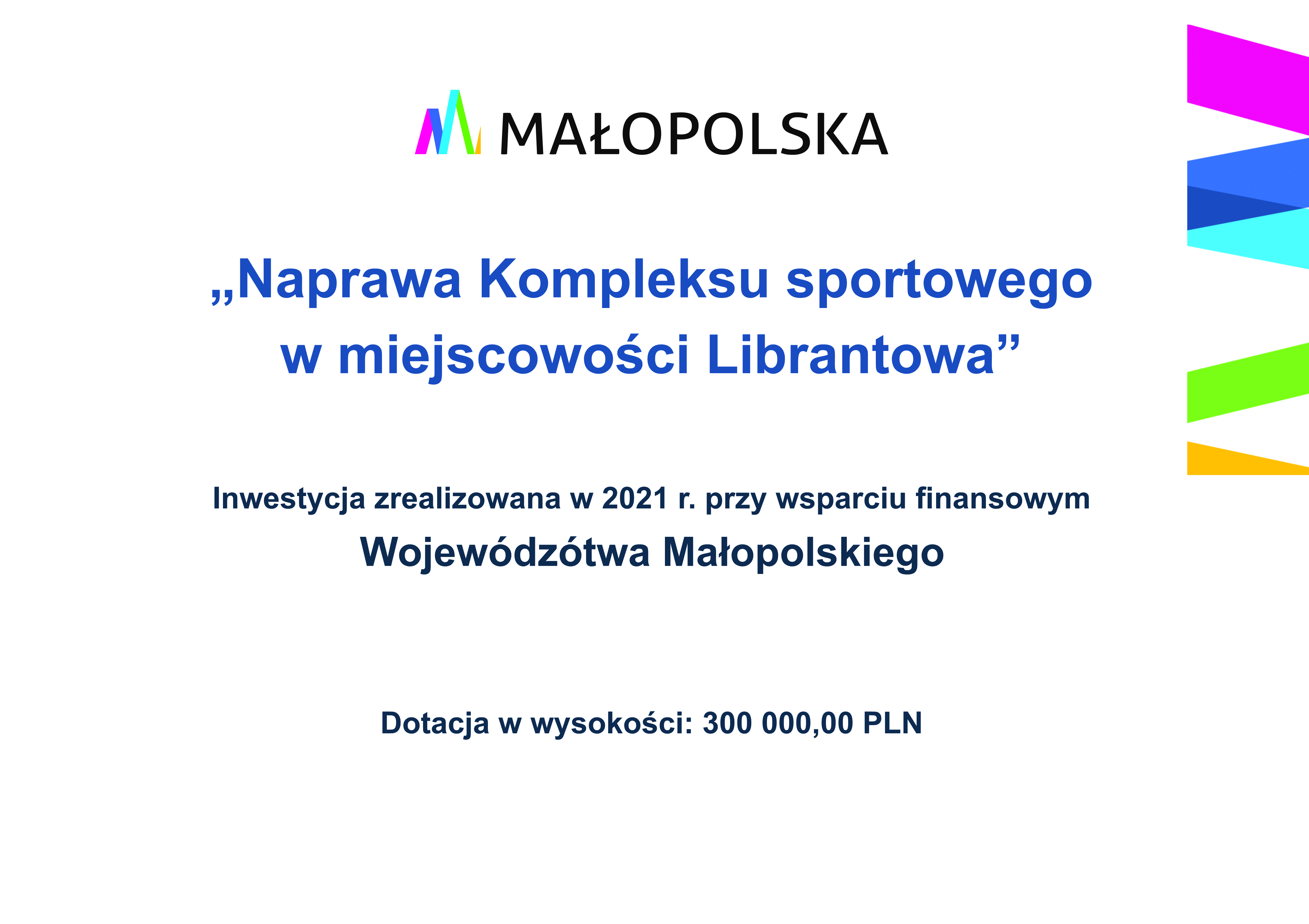 Tablica informacyjna: od góry logo Małopolska, poniżej napis: „Naprawa Kompleksu sportowego  w miejscowości Librantowa”  Inwestycja zrealizowana w 2021 r. przy wsparciu finansowym  Wojewódzótwa Małopolskiego  Dotacja w wysokości: 300 000,00 PLN 